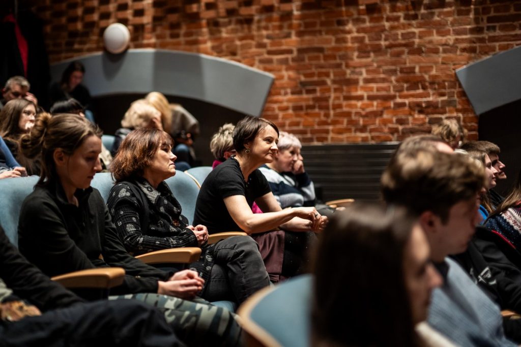 Sala kinowa. Kilkanaście osób siedzi w fotelach. Patrzą w jeden punkt.